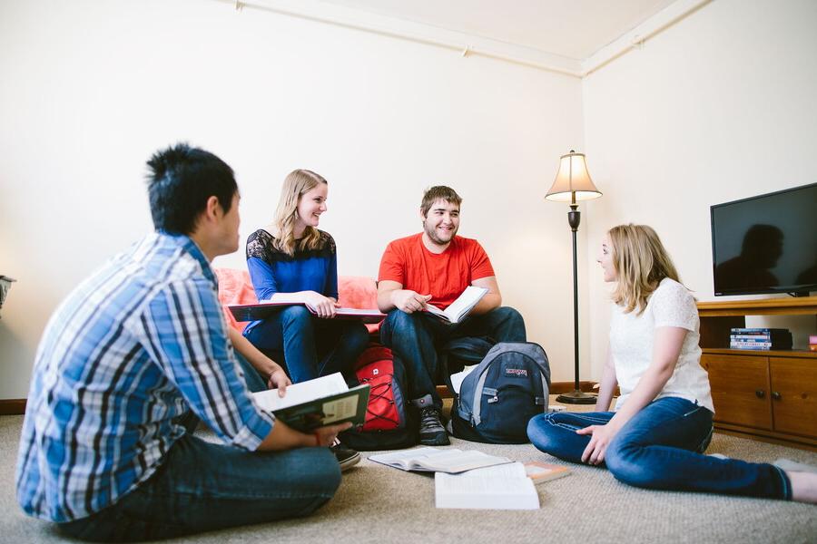 Four students studying in the living room of an apartment.